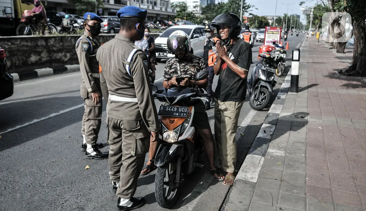 Petugas gabungan memberhentikan pengendara motor yang tidak mengenakan masker di kawasan Sunter, Jakarta, (3/9/2020). Dari total sanksi denda PSBB transisi di Jakarta yang mencapai Rp4 Miliar, Rp2,1 Miliar diantaranya merupakan denda pelanggar tidak menggunakan masker. (merdeka.com/Iqbal Nugroho)