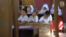 Murid-murid kelas V melakukan kegiatan belajar pada meja yang diubah menjadi kursi dan tempat belajar di SDN Kertajaya 2, Rumpin, Bogor (22/7/2019). Sudah lebih dari tiga tahun mereka belajar  pada fasilitas yang minim. (merdeka.com/Arie Basuki)