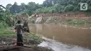 Warga memancing di dekat proyek pembangunan saringan sampah Kali Ciliwung segmen Jalan TB Simatupang, Jakarta, Minggu (12/2/2023).  Kepala Dinas Lingkungan Hidup DKI Jakarta Asep Kuswanto mengatakan pengerjaan proyek saringan sampah di Jalan TB Simatupang molor dari target. (merdeka.com/Iqbal S Nugroho)