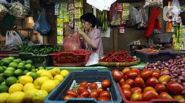 Wahyuning menata kebutuhan pokok dagangannya di Pasar Pondok Labu, Jakarta, Rabu, (8/6/2022). Beberapa harga kebutuhan pokok terus mengalami kenaikan, khususnya cabai rawit merah. (Liputan6.com/Johan Tallo)