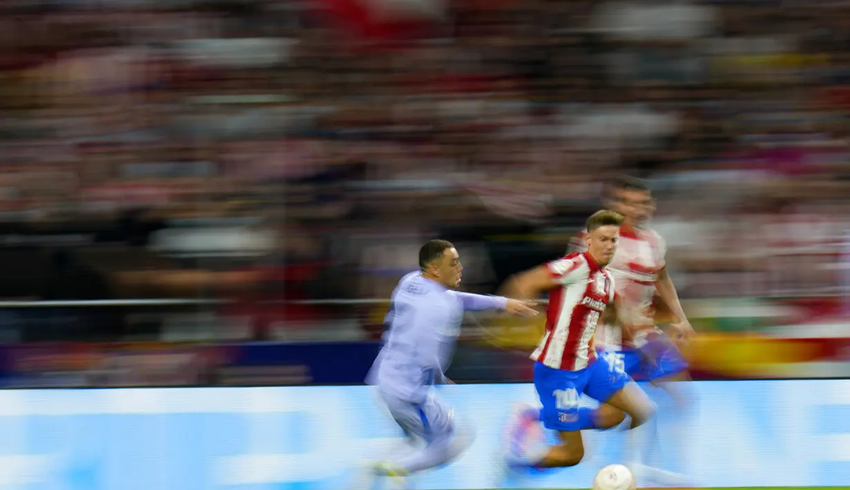 Gelandang Atletico Madrid, Marcos Llorente membawa bola dari kejaran bek Barcelona, Sergino Dest  pada pertandingan lanjutan La Liga Spanyol di Estadio Wanda Metropolitano di Madrid, Minggu (3/10/2021). Atletico Madrid kini berada di urutan kedua klasemen dengan 17 poin. (AP Photo/Manu Fernandez)
