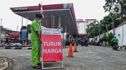 Petugas membawa papan informasi harga turun di SPBU di Jakarta, Selasa (3/1/2023).Selain menurunkan harga Pertamax, pemerintah juga menurunkan harga Pertamax Turbo (RON 98) yang turun harga dari Rp15.200 per liter menjadi Rp14.180 per liter sejak penyesuaian harga terakhir. (Liputan6.com/Angga Yuniar)