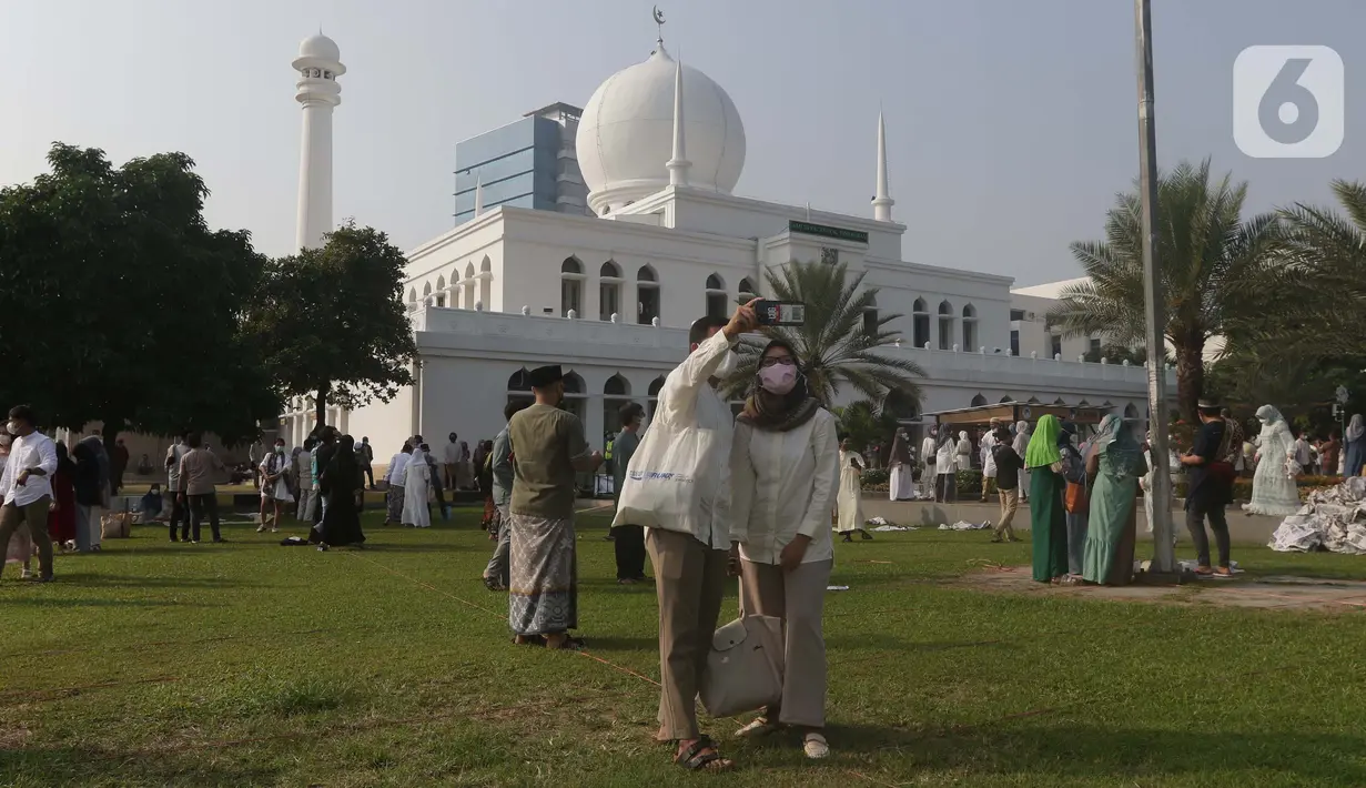 Umat muslim berswafoto usai melaksanakan shalat Idul Fitri 1442 H di Lapangan Masjid Agung Al Azhar, Jakarta, Kamis (13/5/2021). Ribuan umat muslim melaksanakan shalat Idul Fitri 1442 H di Lapangan Masjid Agung Al Azhar dengan menerapkan protokol kesehatan ketat. (Liputan6..com/Helmi Fithriansyah)