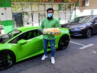 Direktur Pelaksana Pakistan Supermarket Dubai Muhammad Jehanzeb berdiri dekat Lamborghini Huracan sebelum mengirim pesanan mangga di Dubai, Uni Emirat Arab, Kamis (2/7/2020). Supermarket tersebut mengantarkan pesanan mangga untuk minimal pesanan sekitar USD 27. (CACACE GIUSEPPE/AFP)