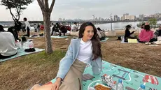 Di tepi Sungai Han, menjadi salah satu tempat yang sangat populer di Korea Selatan untuk menjadi salah satu spot piknik keluarga. Terlihat dalam potret yang diunggah Beby Tsabina tersebut, banyak orang menikmati piknik di tepi sungai. (Liputan6.com/IG/@bebytsabina)