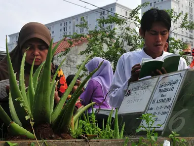 Sebuah keluarga melakukan ziarah dan doa di makam kerabatnya di TPU Karet Bivak, Jakarta, Senin (28/7/14). (Liputan6.com/Johan Tallo)