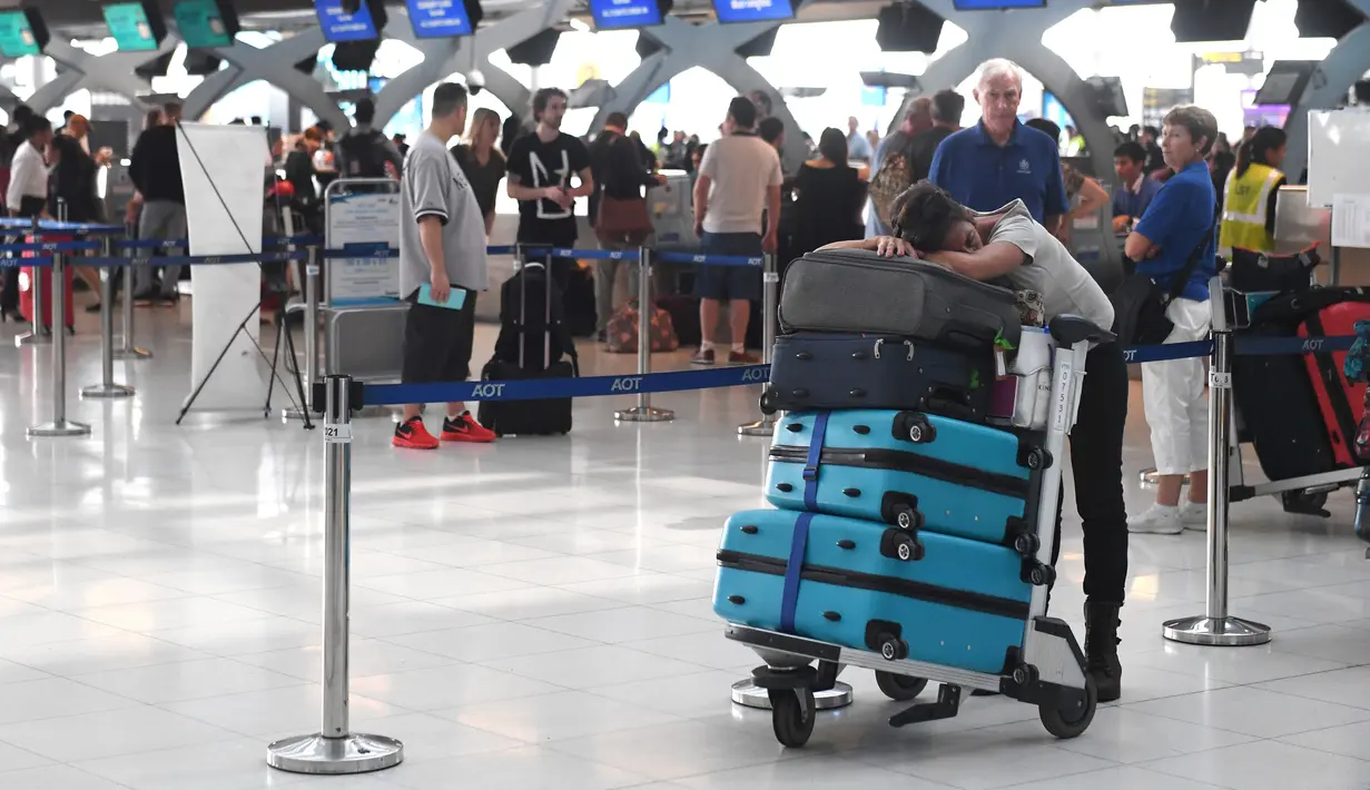 Penumpang beristirahat di area check-in di Bandara Internasional Suvarnabhumi di Bangkok (28/2). Hampir Ribuan penumpang tujuan Pakistan dan Eropa terjebak di bandara tersebut. (AFP Photo/Lillian Suwnrumpha)