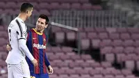 Striker Barcelona berbincang dengan penyerang Juventus, Cristiano Ronaldo, pada laga Liga Champions di Stadion Camp Nou, (8/12/2021). (AFP/Josep Lago)