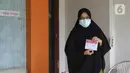 Warga yang diduga terpapar COVID-19 menunjukkan surat suara di kawasan Depok, Jawa Barat, Rabu (9/12/2020). Petugas KPPS melakukan jemput bola atau mengambil suara dari warga yang diduga terpapar COVID-19 atau sedang menjalani isolasi mandiri di Pilkada Depok 2020. (Liputan6.com/Herman Zakharia)