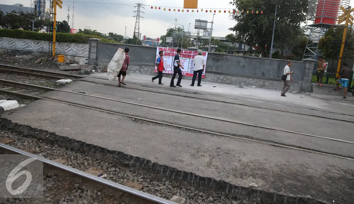 Suasana rel kereta di kawasan stasiun senen dengan spanduk tolak penutupan jalan yang terpampang, Jakarta, Senin (28/11). Menurut warga, penutupan tersebut menimbulkan kemacetan disekitar jalan hinga ke kampung-kampung. (Liputan6.com/Immanuel Antonius)
