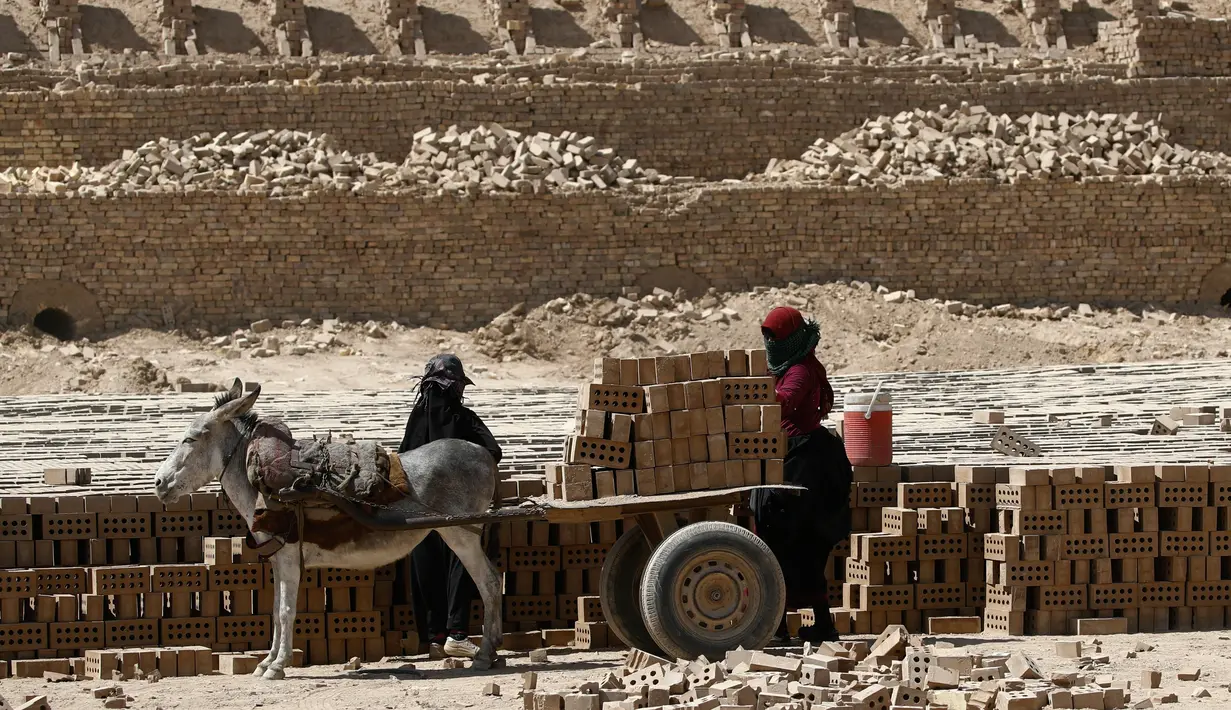 Para wanita bekerja di pabrik batu bata di sebuah pabrik batu bata di Nahrawan, Irak tenggara, Baghdad, Kamis (24/5/2021).  Para pekerja bekerja 12 jam sehari dengan upah sekitar USD$ 15. (AP Photo/Hadi Mizban)
