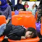 Seorang anak tertidur di kursi bersama keluarganya menunggu verifikasi data TKI dari petugas BP3TKI Serang di Bandara Soekarno Hatta, Tangerang, Sabtu (10/06). (Liputan6.com/Fery Pradolo)