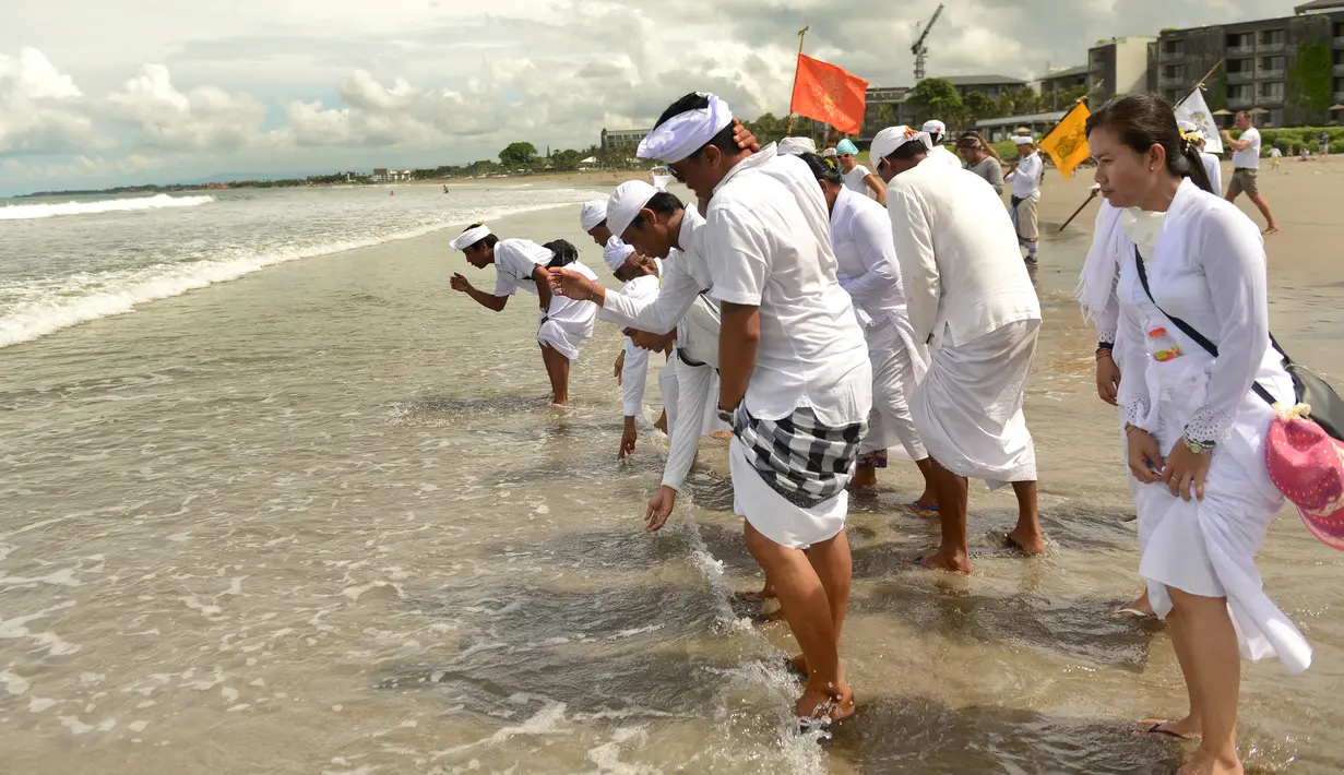 Umat Hindu Bali mengamnil air bersiap melakukan upacara Melasti di pantai Petitenget, Bali, Rabu (14/3). Melasti ini merupakan bagian dari empat tahapan yang dilaksanakan pra-Nyepi, atau sebelum Nyepi. (AFP Photo/Sonny Tumbelaka)