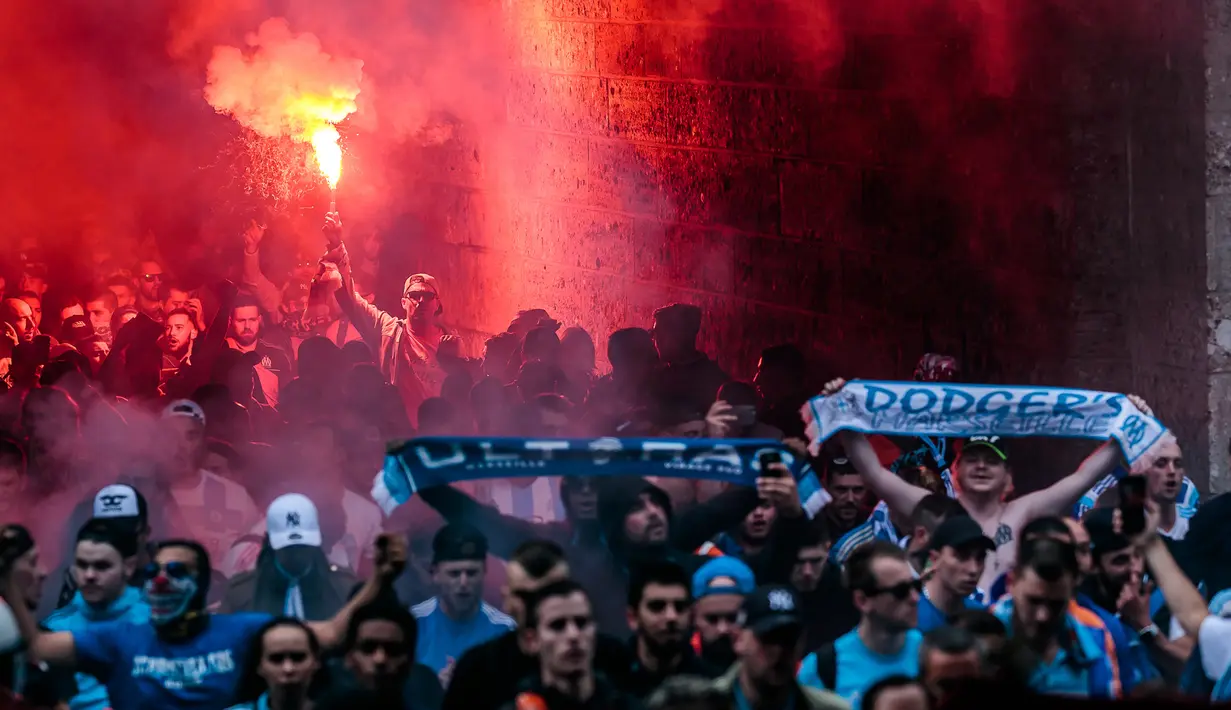 Para pendukung tim sepak bola Prancis, Olympique Marseille menyalakan flare dalam perjalanan mereka ke Red Bull Arena untuk menonton pertandingan melawan tim tuan rumah FC Salzburg di Austria (3/5). (JFK / EXPA / APA / AFP)