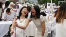 Dua wanita berpakaian serba putih bersuka ria dalam Diner en blanc di Rockefeller Park, New York, Rabu (17/7/2019). New York City Diner en Blanc adalah sebuah pesta makan malam rahasia dengan pakaian bernuansa putih yang diadopsi dari budaya Prancis. (TIMOTHY A. CLARY / AFP)