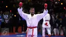 Karateka Jawa Timur, Umar Syarief mengangkat tangan usai menumbangkan Caesar George (Jakarta) di kelas Kumite Individu Putra +84 kg senior PON XIX di Sabuga, Bandung, Minggu (18/9). Umar menang telak 9-1 atas Caesar. (Liputan6.com/Helmi Fithriansyah)