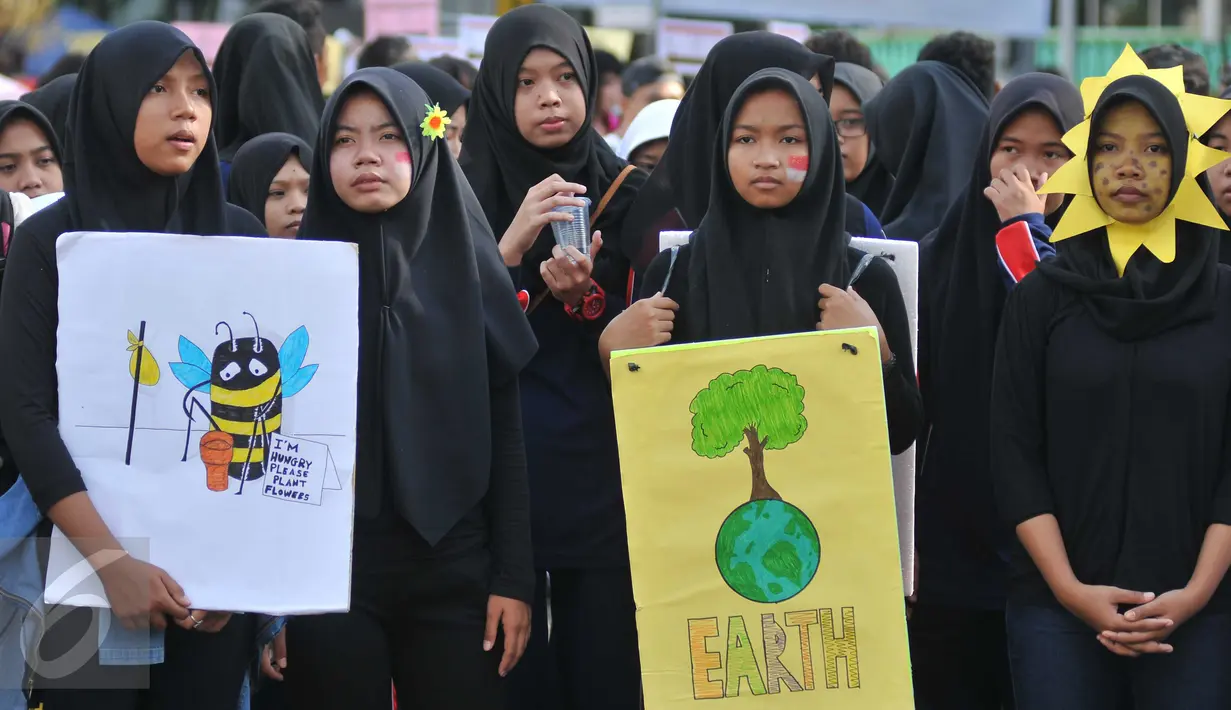 Sejumlah orang peduli lingkungan melakukan aksi di Bundaran HI, Jakarta, Minggu (22/4). Kegiatan tersebut guna memperingati Hari Bumi Internasional serta mengkampanyekan cinta lingkungan untuk masa depan. (Liputan6.com/Gempur M Surya)
