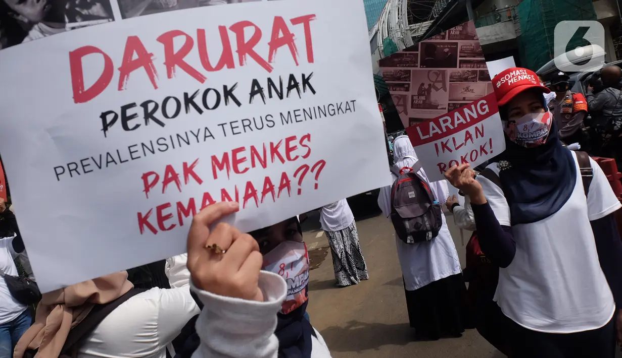 Massa Aliansi Kompak menujukkan poster tuntutan saat menggelar aksi di depan Kemenkes, Jakarta, Kamis (26/11/2020). Revisi Peraturan Pemerintah No. 109 Tahun 2012 (PP 109/2012) terkait pengamanan bahan yang mengandung zat adiktif berupa produk tembakau bagi kesehatan. (Liputan6.com/Herman Zakharia)