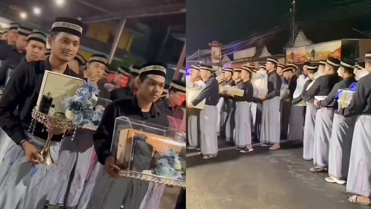 Para santri berseragam baju koko hitam dengan sarung abu-abu dan kopiah itu berbaris sambil membawa seserahan balasan lamaran Gus Sunny dari pihak keluarga Ning Nayluf.