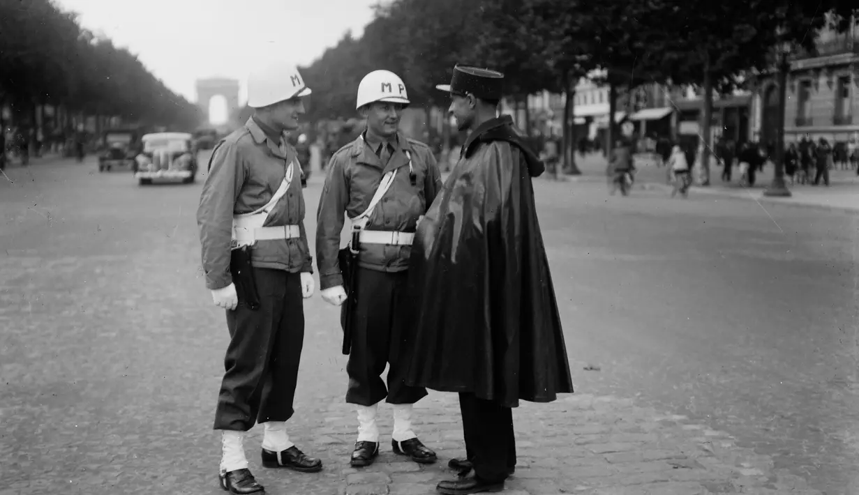 Dua tentara polisi militer AS berbicara dengan polisi militer saat berpatroli di Champs Elysees Avenue, pada November 1944 di Paris. (AFP Photo)