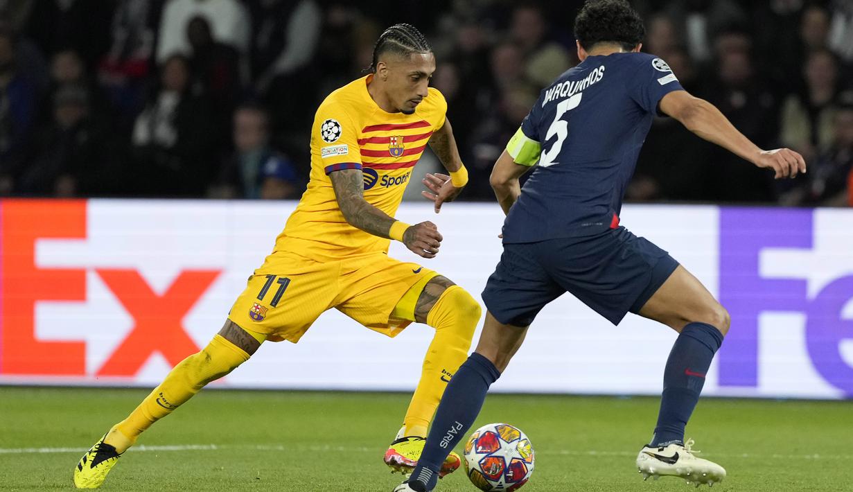 Pemain Barcelona, Raphinha, berusaha melewati pemain Paris Saint-Germain, Marquinhos, pada laga leg pertama perempat final Liga Champions di Stadion Parc des Princes, Kamis (11/4/2024). (AP Photo/Lewis Joly)
