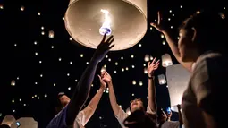 Warga melepaskan lampion ke udara saat perayaan festival Yee Peng di Chiang Mai (3/11). Dalam festival ini, ratusan bahkan ribuan orang beramai-ramai menerbangkan lampion. (AFP Photo/Roberto Schmidt)