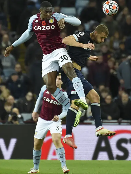 Bek Aston Villa, Kortney Hause melompat saat berebut bola dengan gelandang West Ham United, Tomas Soucek pada pekan sepuluh Liga Inggris di Villa Park, Minggu (31/10/2021). West Ham United mengandaskan tuan rumah Aston Villa dengan skor 4-1. (AP Photo/Rui Vieira)