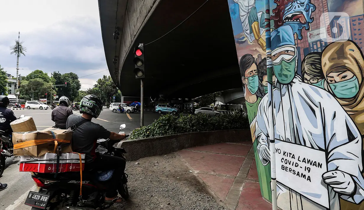 Pengendara motor menunggu lampu merah di dekat mural melawan COVID-19 di Jakarta, Kamis (17/11/2020). Sebelumnya, Presiden Joko Widodo (Jokowi) menegaskan bahwa pemerintah sangat optimistis dalam pengendalian pandemi Covid-19. (Liputan6.com/JohanTallo)