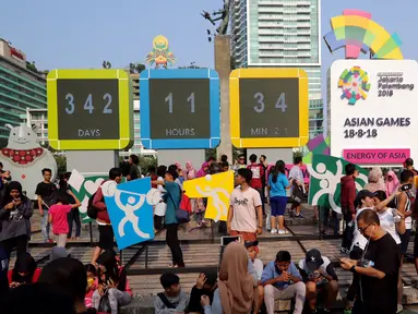 Warga memadati layar Countdown Asian Games 2018 saat Car Free Day di Bundaran HI, Jakarta, Minggu, (10/09). Layar Countdown Asian Games 2018  ini menandai hitung mundur untuk pelaksanaan Asian Games 2018. (Liputan6.com/Fery Pradolo)
