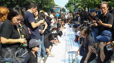 Para pendukung Ahok membubuhkan tandatangan saat aksi di depan Balaikota, Jakarta, Sabtu (13/5). Massa pendukung Ahok menggelar aksi pengumpulan KTP untuk membebaskan Ahok dari jeratan vonis dua tahun penjara. (Liputan6.com/Yoppy Renato)