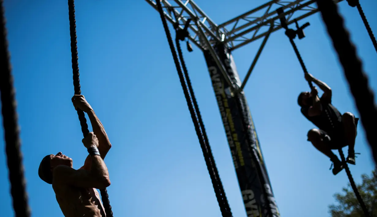 Dua pria memanjat tali saat mengikuti kompetisi Tough Viking di Stockholm, Swedia (12/5). Dalam lomba ini peserta harus menempuh jarak 8 km dengan 26 rintangan berat. (AFP/Jonathan Nackstrand)