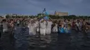 Orang-orang berpartisipasi dalam ritual untuk dewi laut Afrika Yemanja di Pantai Ramirez di Montevideo, Uruguay, Rabu (2/2/2022). Para pemuja mendatangi pantai pada pada hari raya Yemanja, membawa lilin, bunga, madu dan buah untuk menghormati dewi laut. (AP Photo/Matilde Campodonico)