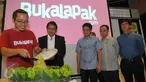 CEO dan founder Bukalapak Achmad Zaky (kiri) memotong tumpeng disaksikan Menkominfo Rudiantara (kedua kiri) saat perayaan ulang tahun yang ke-6 serta peresmian kantor baru mereka di kawasan Kemang, Jakarta, Selasa (12/1). (Liputan6.com/Faisal R Syam)