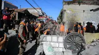 Satpol PP Kota Surabaya membongkar tembok yang memblokir jalan umum di Jalan Tambak Wedi Baru. (Foto: Liputan6.com/Dian Kurniawan)