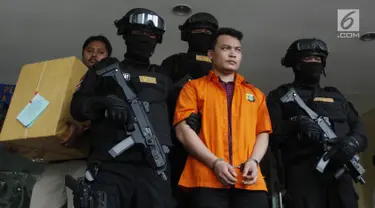 Tersangka pembunuh satu keluarga di Bekasi Haris Simamora (tengah) mendapat pengawalan polisi bersenjata di Polda Metro Jaya, Jakarta, Kamis (21/2). Polda Metro Jaya melimpahkan berkas perkara kasus Haris ke Kejari Bekasi. (Merdeka.com/Imam Buhori)