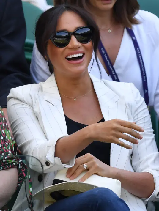 Meghan Markle menyaksikan sahabatnya yang juga petenis AS Serena Williams melawan Kaja Juvan dari Slovakia pada babak kedua Wimbledon di All England Lawn Tennis Club, London, Kamis (4/7/2019). Istri Pangeran Harry itu menjadi saksi Serena mengalahkan Kaja Juvan 2-6, 6-2, 6-4. (AP Photo)