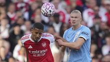 Pemain Arsenal, William Saliba (kiri), berduel dengan striker Man City, Erling Haaland, pada pekan 5 Liga Inggris 2025/2026 di Emirates Stadium, Minggu (21/9/2025) malam WIB. (AP Photo/Kin Cheung)