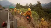 Petugas pemadam kebakaran saat berusaha melokalisir kebakaran hutan yang terus meluas di Mentone, California, Minggu 8 September 2024. (AP Photo/Eric Thayer)