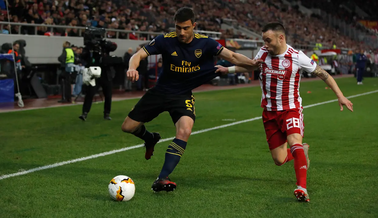 Bek Arsenal, Sokratis Papastathopoulos berebut bola dengan pemain Olympiakos Piraeus, Mathieu Valbuena pada leg pertama babak 32 besar Liga Europa di Georgios Karaiskakis Stadium, Kamis (20/2/2020). Arsenal susah payah menaklukkan Olympiakos Piraeus 1-0. (AP/Thanassis Stavrakis)