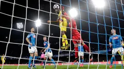 Kiper Napoli David Ospina (kanan) melakukan penyelamatan saat pemain Barcelona Samuel Umtiti mencoba mencetak gol pada pertandingan babak 16 besar Liga Champions di San Paolo Stadium, Naples, Italia, Selasa (25/2/2020). Pertandingan berakhir dengan skor 1-1. (Alfredo Falcone/Andrew Medichini)