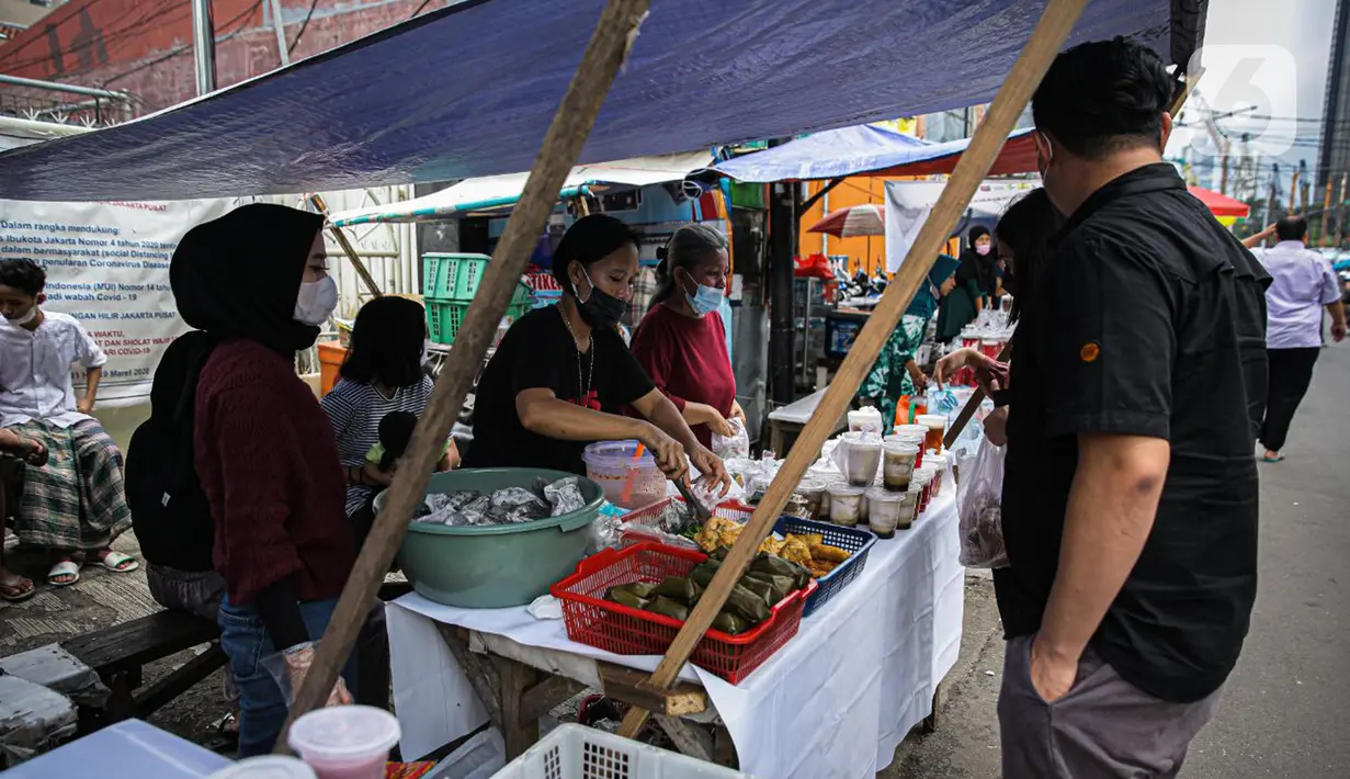 Pedagang melayani pembeli di Pasar Takjil Benhil, Jakarta, Selasa (13/4/2021). Pasar takjil yang ada setiap bulan Ramadhan tersebut dipadati warga untuk membeli makanan berbuka puasa. (Liputan6.com/Faizal Fanani)