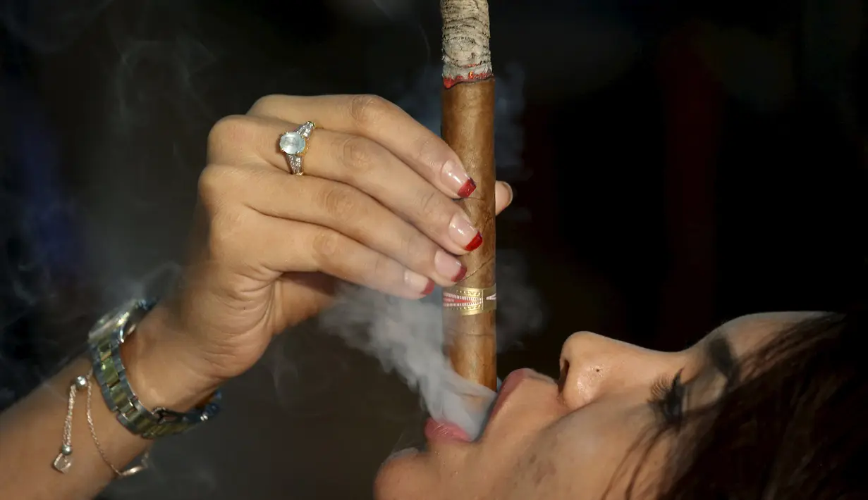 Seorang peserta wanita saat berkompetisi membuat sisa abu cerutu terpanjang di Festival Habanos tahunan XVIII di Havana, Kuba, (3/3) Cerutu Kuba merupakan salah satu cerutu terbaik dan termahal di dunia. (REUTERS/Alexandre Meneghini)