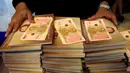 Pegawai bank menunjukan uang kertas 100 baht edisi ulang tahun Raja Thailand Bhumibol Adulyadej ke-84 di kantor pusat Bank Tabungan Pemerintah di Bangkok, Thailand (18/10). (Reuters/Edgar Su)