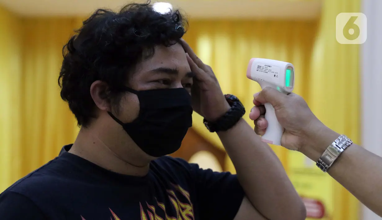 Petugas melakukan pengecekan suhu tubuh calon peserta Rapid Test COVID-19 di DPP Partai Golkar, Jakarta, Rabu (8/4/2020). Di Indonesia, rapid test dilakukan dengan menggunakan sampel darah. (Liputan6.com/Helmi Fithriansyah)