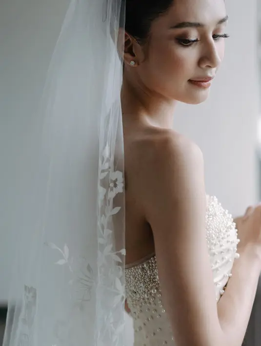 Sama-sama memakai aksesori veil, namun Mikha Tambayong membuat look-nya lebih dramatis dengan veil menjuntai dan sang mama lebih minimalis. [@thebridestory]