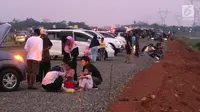 Pemudik menyantap hidangan berbuka puasa di pinggir Tol Fungsional Pemalang-Batang, Jawa Tengah, Minggu (10/6). Sambil berbuka mereka juga mendinginkan kendaraannya. (Liputan6.com/Arya Manggala)