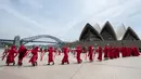 Aktivis yang terbagung dalam kelompok Red Rebels berunjuk rasa dalam demonstrasi protes iklim di Sydney (15/12/2019). Pengunjuk rasa melakukan aksi di depan landmark Gedung Opera Sydney menuntut pemerintah Australia menanggulangi asap yang menyebabkan masalah kesehatan. (AFP/Wendell Teodoro)