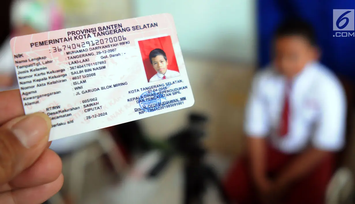 Petugas menunjukkan Kartu Identitas Anak (KIA) yang telah jadi di SD Negeri 01 Sawah Baru, Ciputat, Jumat (27/4). Pembuatan KIA ini diselengarakan oleh Dinas Kependudukan dan Pencatatan Sipil Kota Tangsel (Disdukcapil). (Merdeka.com/Arie Basuki)