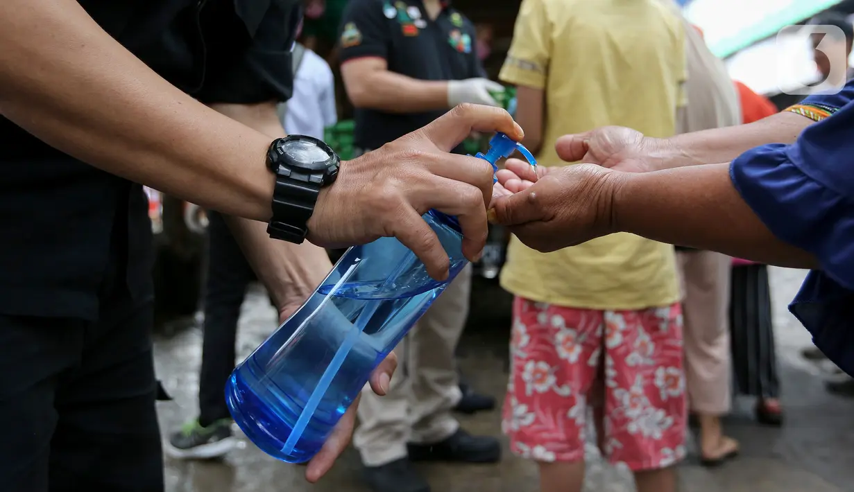Warga membersihkan tangan menggunakan hand sanitizer saat antre Operasi Pasar di Pasar Palmerah, Jakarta, Jumat (20/3/2020). Di tengah merebaknya virus corona Perum Bulog menggelar Operasi Pasar untuk mencegah panic buying dengan harga murah. (Liputan6.com/Fery Pradolo)