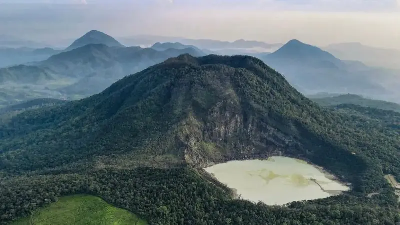 Pemandangan indah Kawah Putih di Gunung Patuha dengan airnya yang berwarna putih kehijauan dan dikelilingi oleh bebatuan kapur